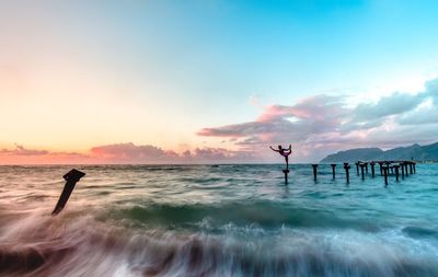 Silhouette man standing on beach against sky during sunset