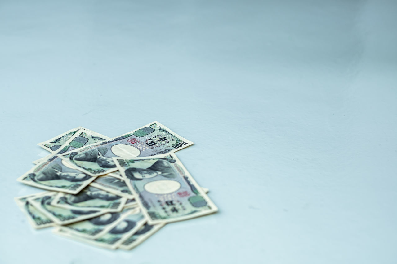 CLOSE-UP OF BLUE PAPER OVER WHITE TABLE