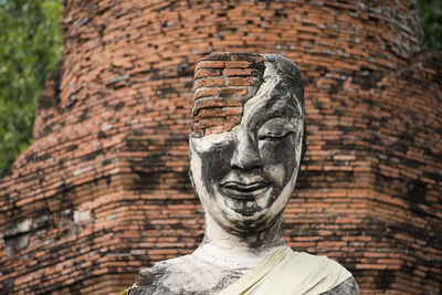 Low angle view of old damaged buddha statue and temple