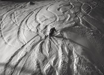 High angle view of silhouette person skiing on snow covered field at brighton ski resort during night