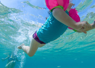 Low section of girl swimming in sea