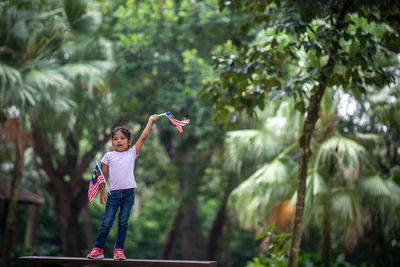 Full length of girl standing by tree