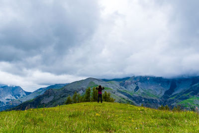 A young female hiker on a break during a hike on a cloudy summer day in the french alps