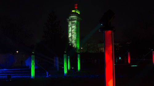 Low angle view of illuminated clock tower at night