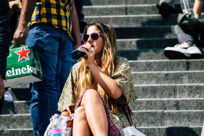 Young woman sitting on staircase in city