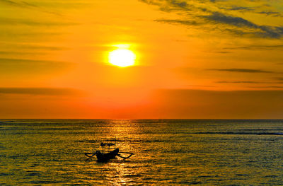 Silhouette boat in sea against sky during sunset