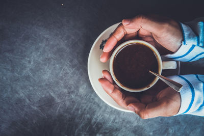 Directly above shot of person holding tea cup on table