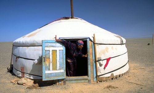 Rear view of man in desert against clear sky