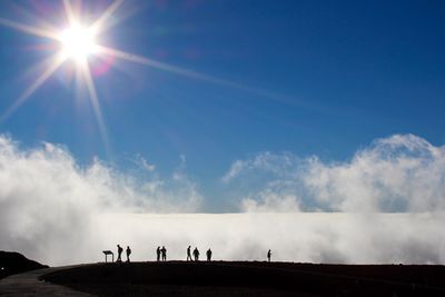 Silhouette people against bright sun at haleakala national park