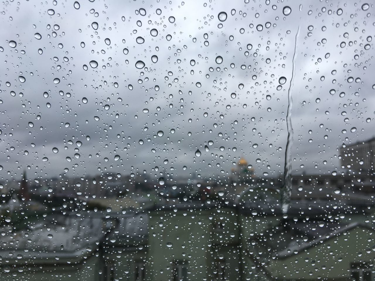 CLOSE-UP OF WET WINDOW AGAINST SKY