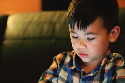 Close-up portrait of boy looking at home
