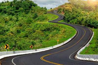 Scenic view of road amidst trees against sky