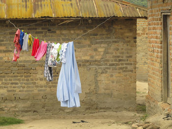 Clothes drying on clothesline against wall of building