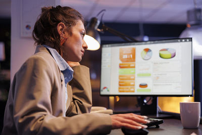 Side view of man using laptop at office