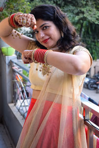 Beautiful woman dressed up as indian tradition with henna mehndi design on her both hands