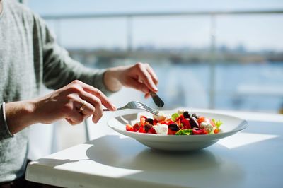 Midsection of man preparing food in bowl on table