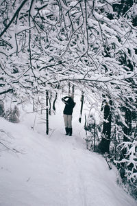 Rear view of man walking on snow covered landscape