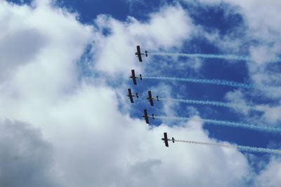 Low angle view of airshow against cloudy sky