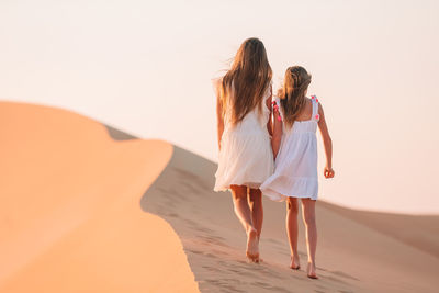 Rear view of women standing on beach