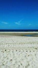 Scenic view of beach against blue sky