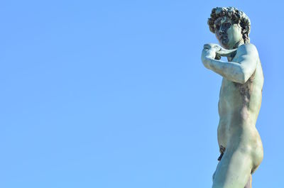 Low angle view of statue against blue sky