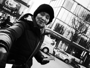 Portrait of young man standing in city