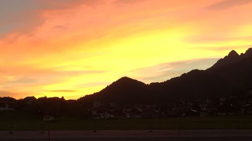 Scenic view of silhouette landscape against orange sky