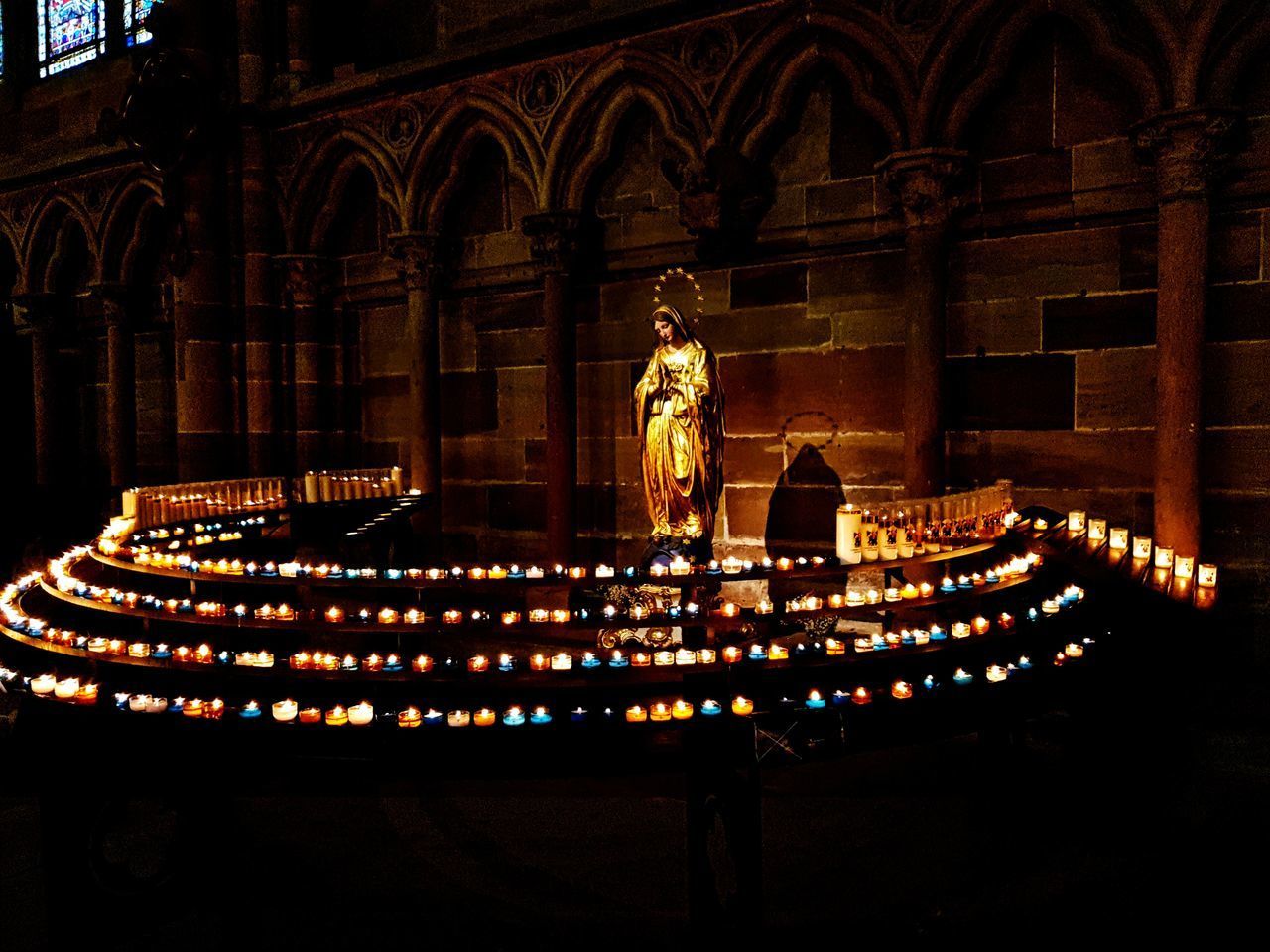 STATUE OF ILLUMINATED TEMPLE AGAINST BUILDING AT NIGHT