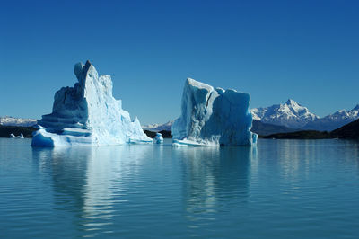 Scenic view of frozen lake against clear blue sky