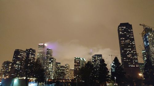 Low angle view of illuminated cityscape against sky at night