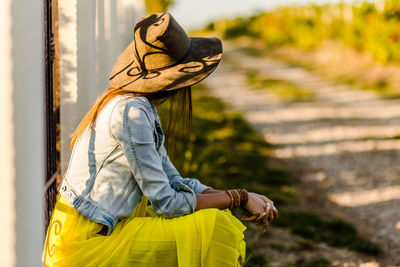 Side view of woman wearing hat standing outdoors