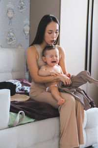 Portrait of young woman sitting on sofa at home