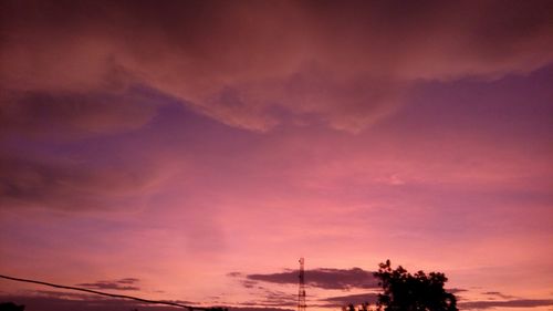 Low angle view of silhouette trees against dramatic sky