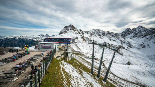 Panoramic view of people on snowcapped mountains against sky