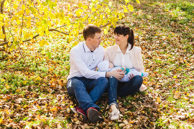 Young man sitting on field during autumn