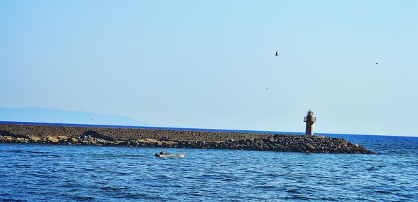 Man standing by sea against clear sky