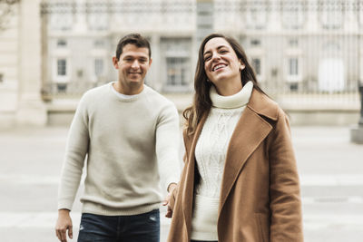 Smiling young couple standing in city