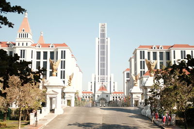 Street amidst buildings against clear sky
