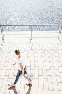 High angle view of people on footpath by sea