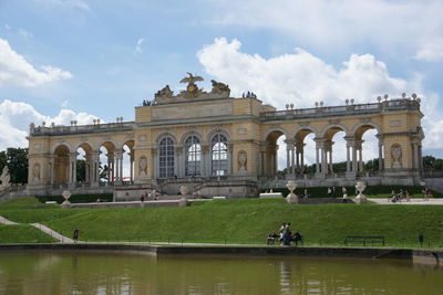 Lake in front of historic building against sky