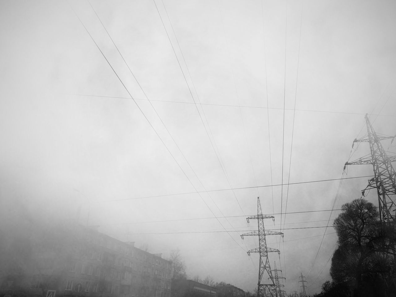 LOW ANGLE VIEW OF ELECTRICITY PYLON AGAINST SKY DURING FOGGY WEATHER
