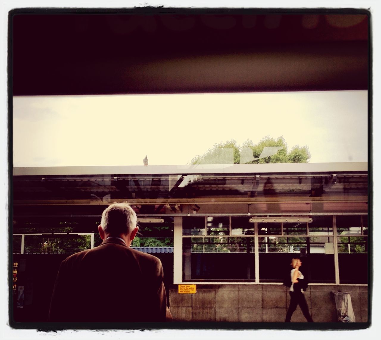 men, transfer print, rear view, lifestyles, person, auto post production filter, built structure, architecture, leisure activity, railing, sitting, clear sky, transportation, full length, standing, looking at view, indoors