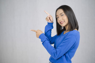 Portrait of a smiling young woman against white background