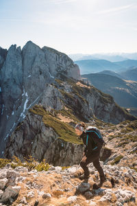 Man walking on rock against sky