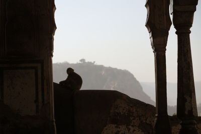 Silhouette man standing in temple against clear sky