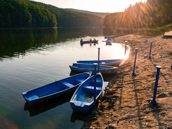 Boats moored in lake against sky