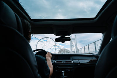  man driving car on cable bridge in the city