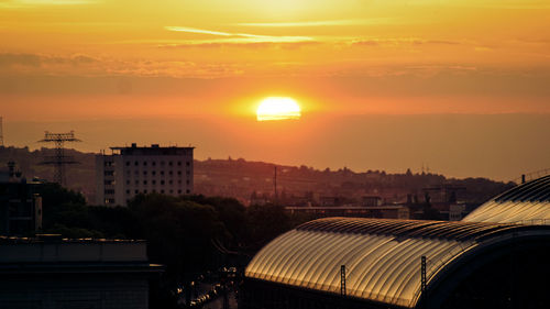 Buildings in city against sky during sunset