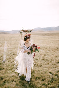 Woman standing on field against sky