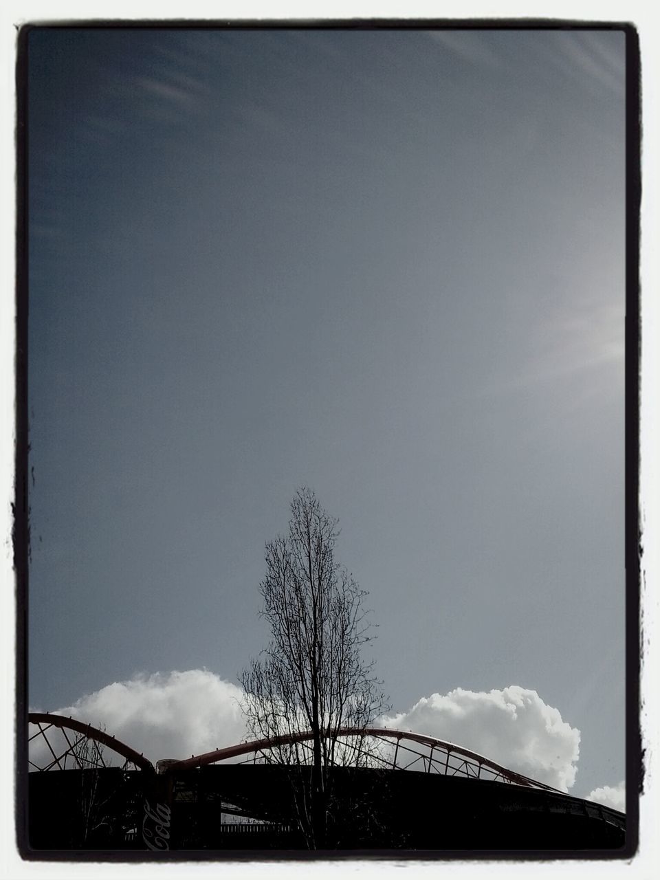 low angle view, sky, built structure, transfer print, architecture, auto post production filter, connection, silhouette, high section, tree, cloud, cloud - sky, bridge - man made structure, outdoors, building exterior, no people, railing, day, blue, nature